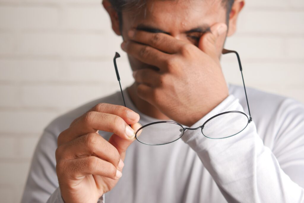 man with the glasses with hands on head